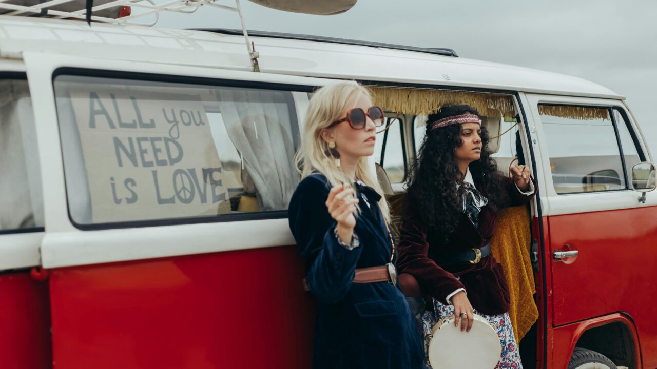 Women Standing Beside a Red Kombi