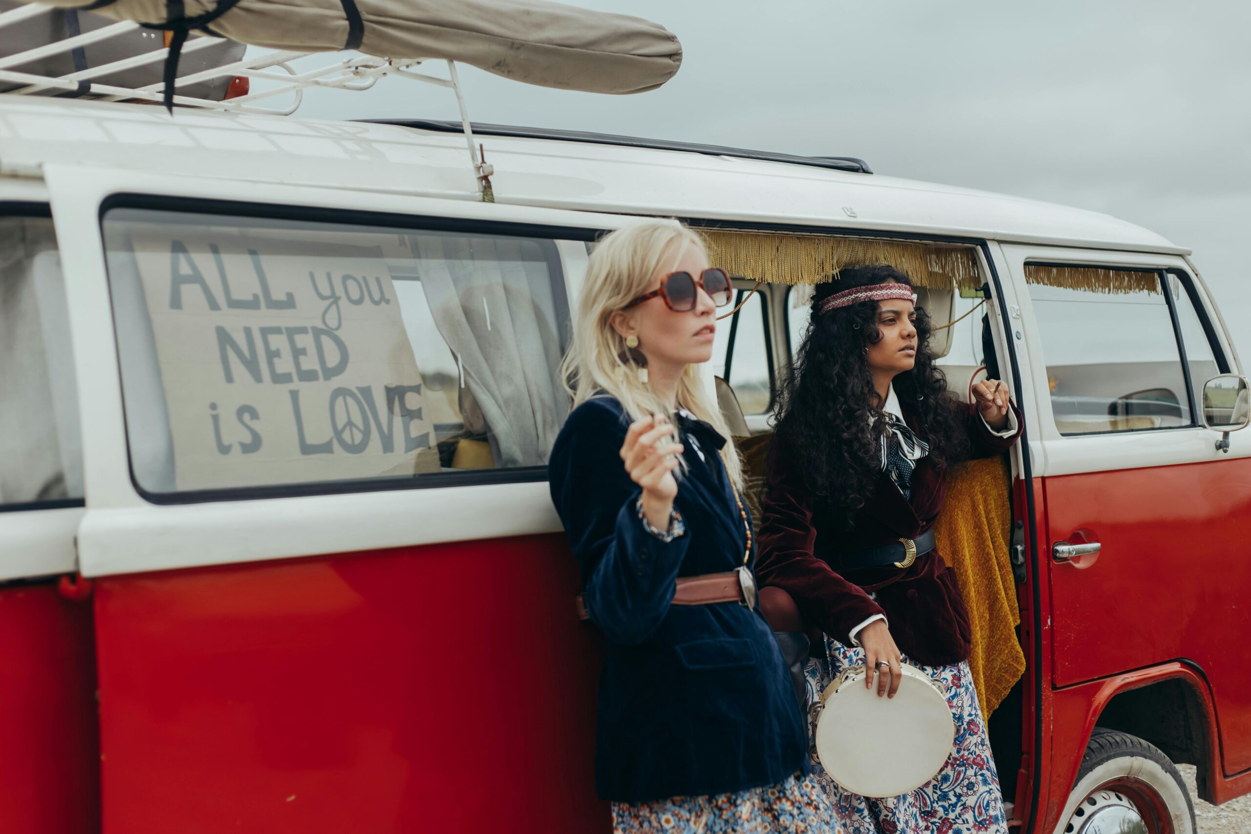 Women Standing Beside a Red Kombi