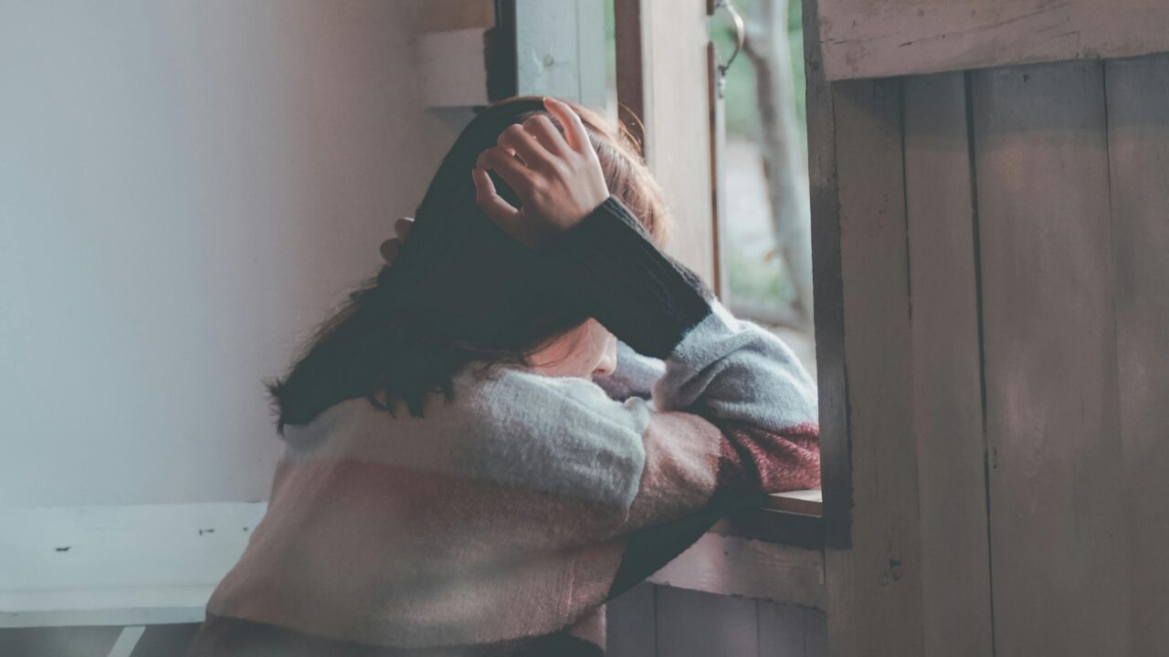 Photo of a Person Leaning on Wooden Window