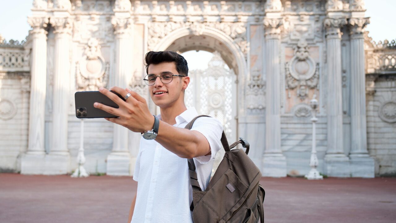 Young Man Taking a Selfie in front of the Dolmabahce Palace in Istanbul, Turkey