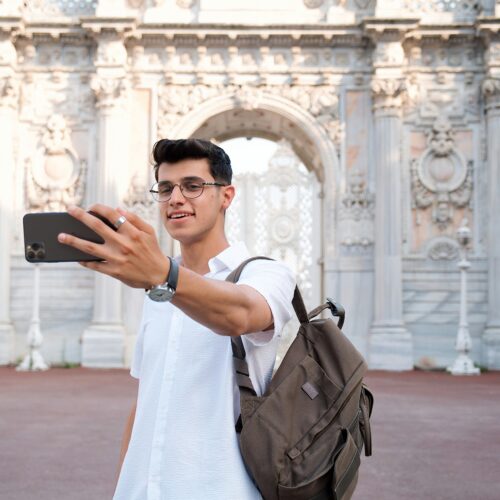 Young Man Taking a Selfie in front of the Dolmabahce Palace in Istanbul, Turkey