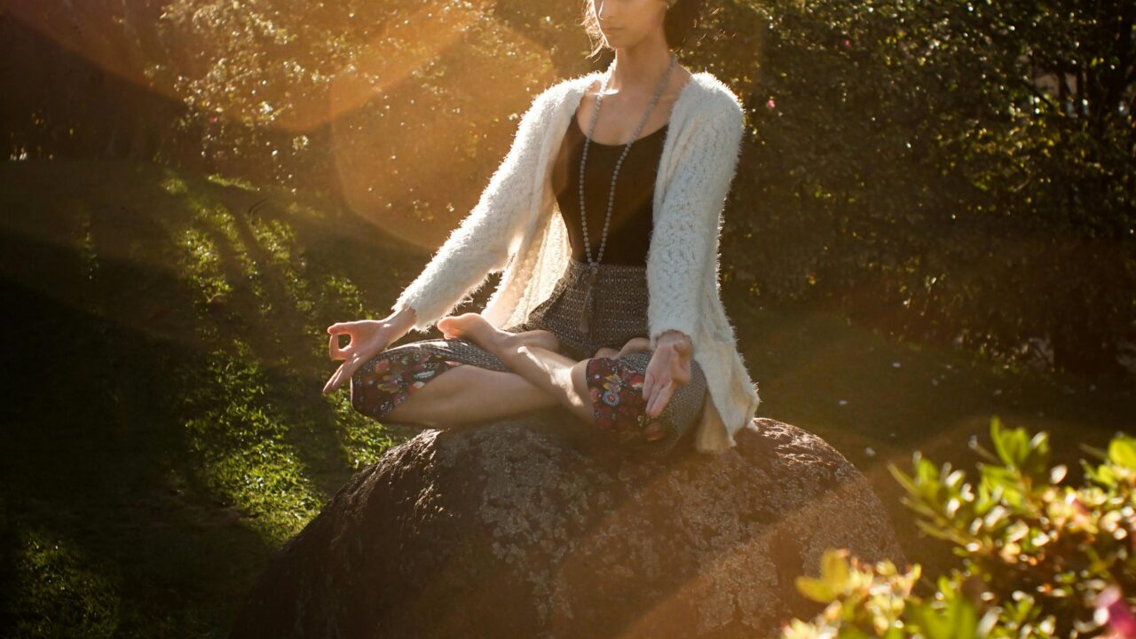 Woman Meditating on Rock