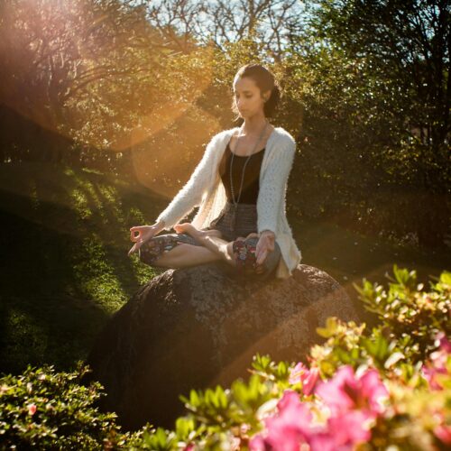 Woman Meditating on Rock