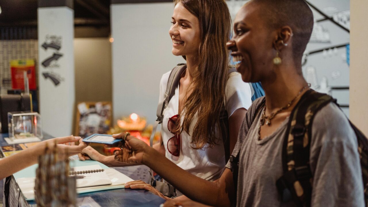 Women Receiving a Hotel Room Card at the Reception Desk 