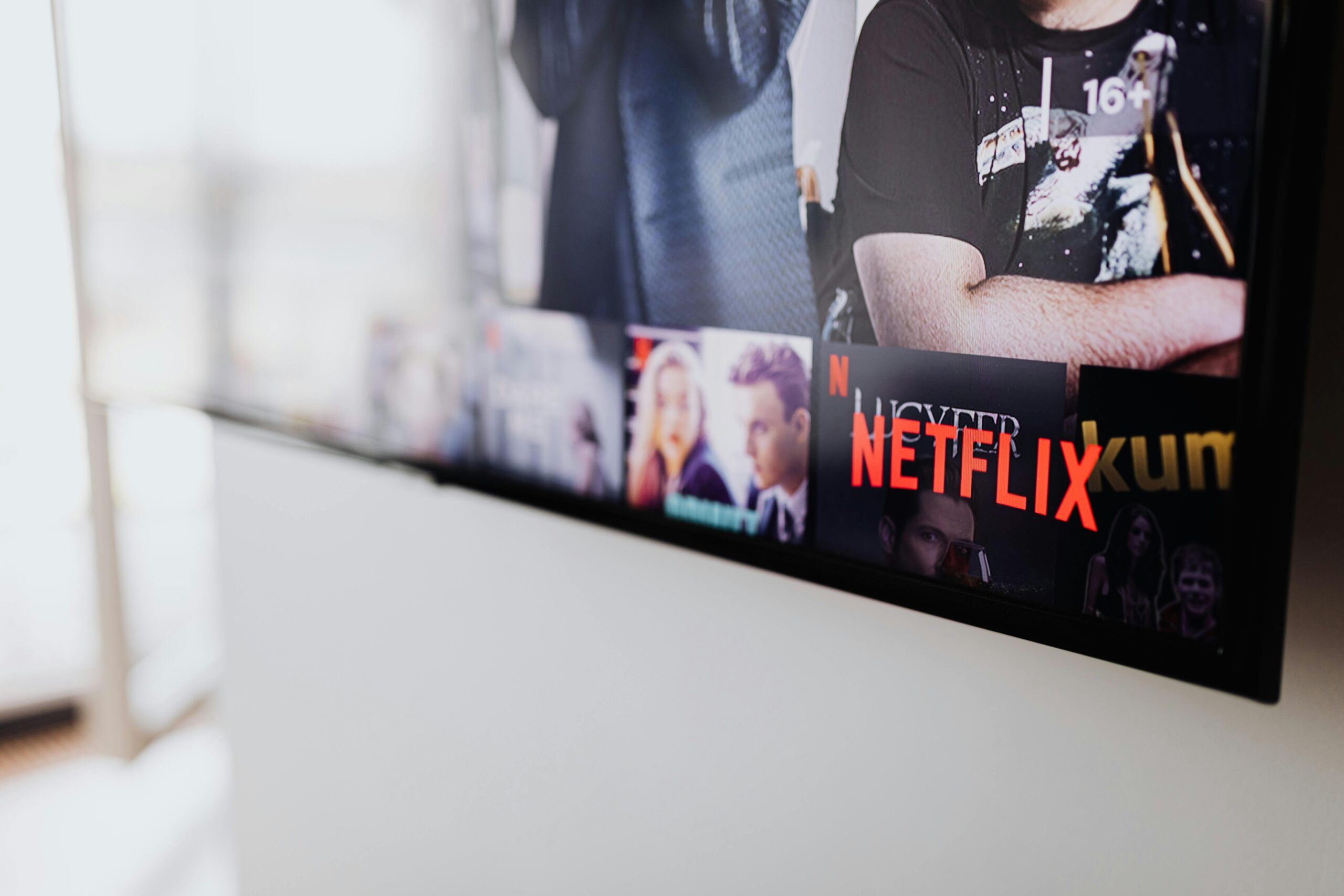 Black Flat Screen Tv Turned on Showing Man in Black Shirt