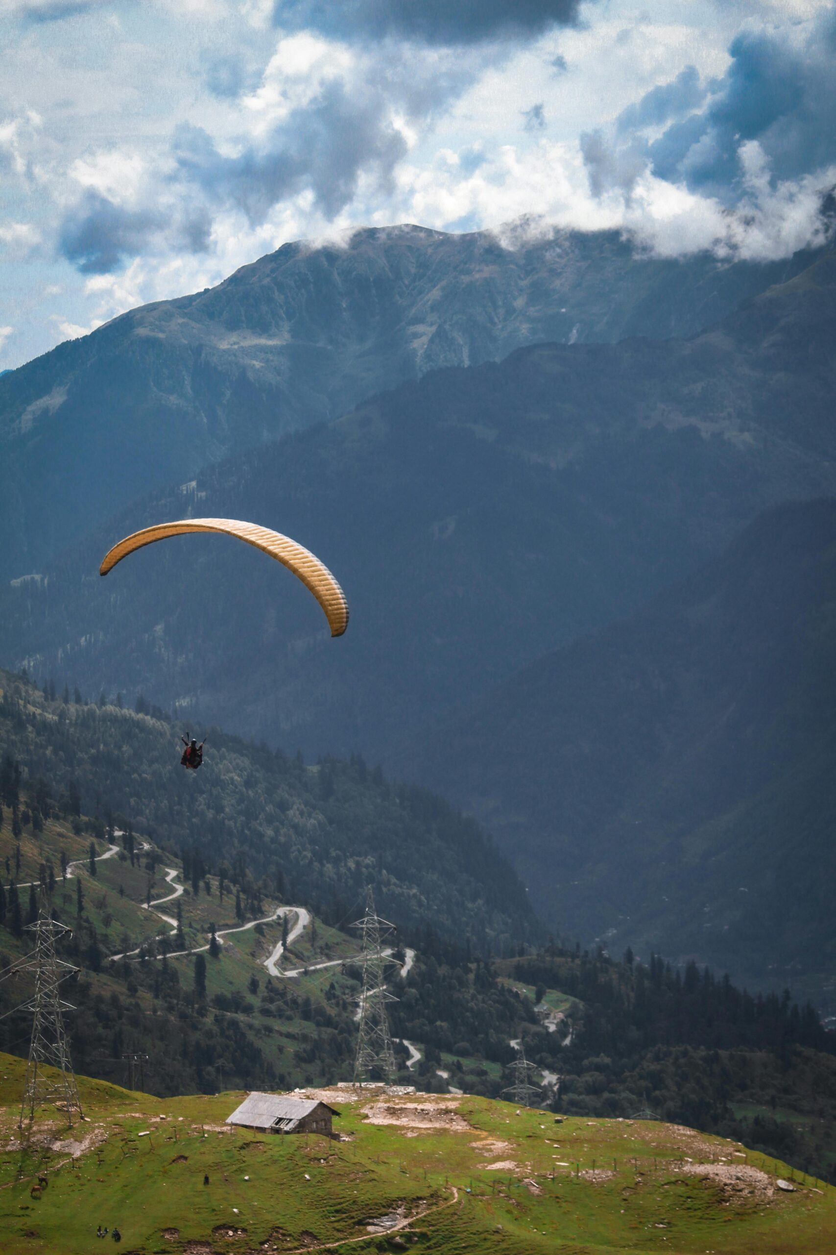 Person Riding Yellow Parachute over Mountain Range