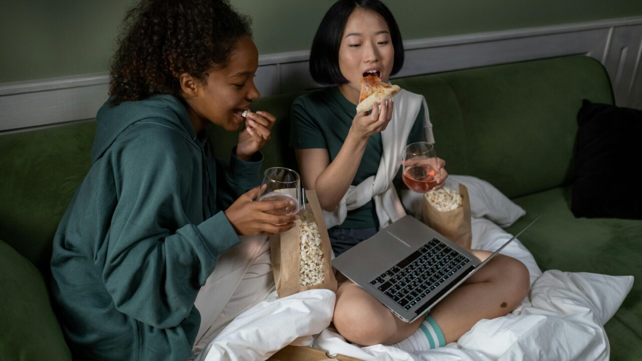 A Couple Watching on a Laptop while Eating