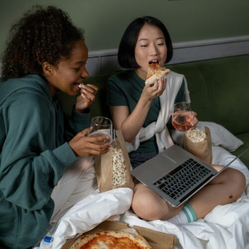 A Couple Watching on a Laptop while Eating