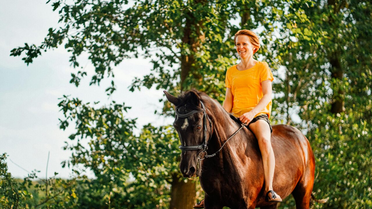 Photo of Woman Riding Horse Near Tree